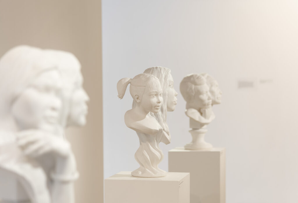 three classical busts in a row, one in sharp focus in the middle of a little girl
