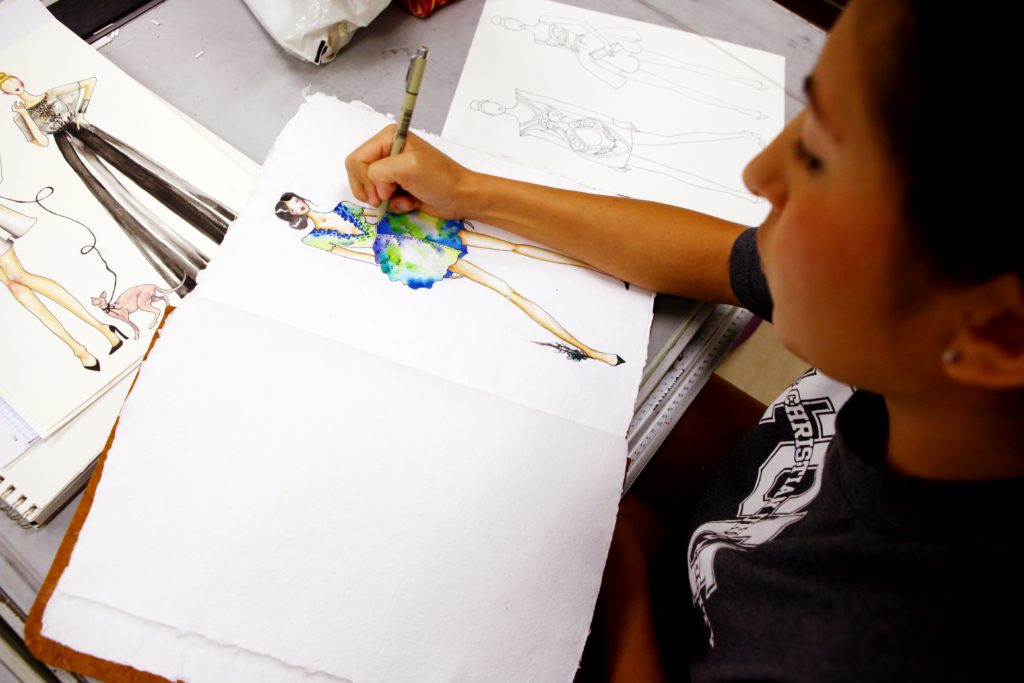 Student sketches fashion figure