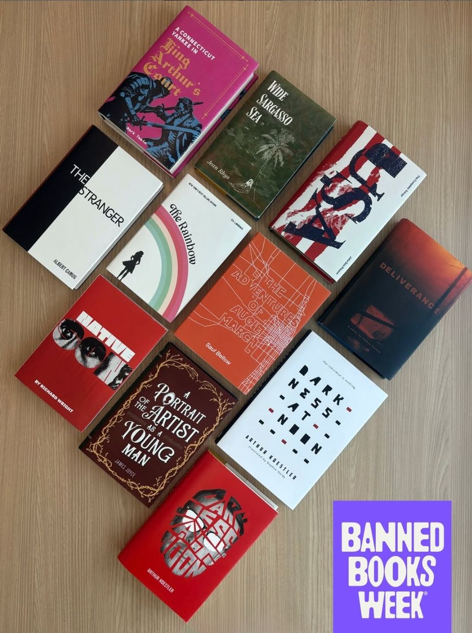 Ten student-designed book jackets are arranged on a wooden surface, showcasing creative typography, illustrations and bold colors. The designs reinterpret challenged and banned literary works as part of TCU's annual Banned Book Jacket Competition. A purple Banned Books Week graphic appears in the lower right corner.