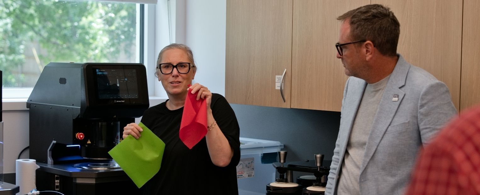 Leslie Browning-Samoni demonstrates fabric materials alongside Charles Freeman in TCU’s Athlete Equipment and Materials Design Lab.