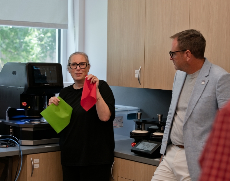 Leslie Browning-Samoni demonstrates fabric materials alongside Charles Freeman in TCU’s Athlete Equipment and Materials Design Lab.