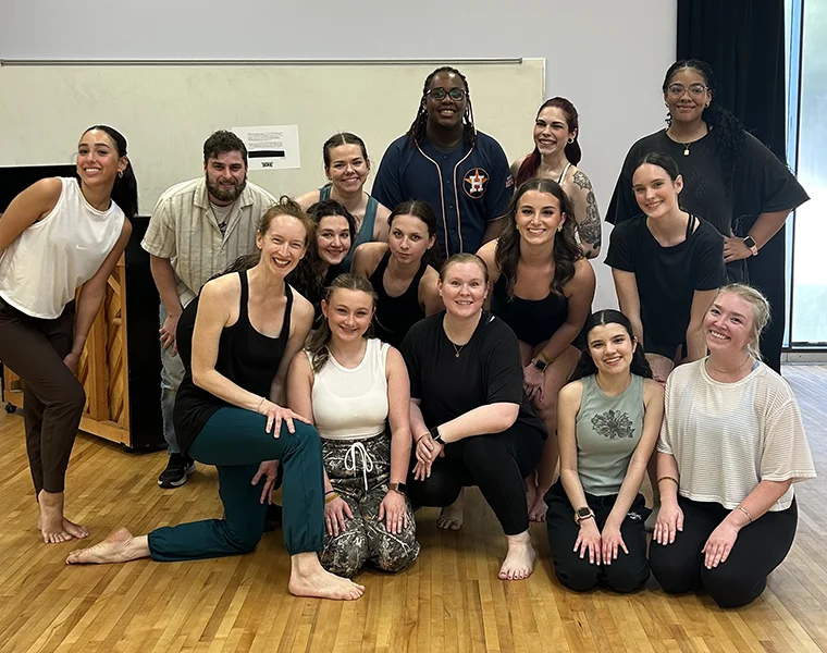 A group of dancers gather in the studio