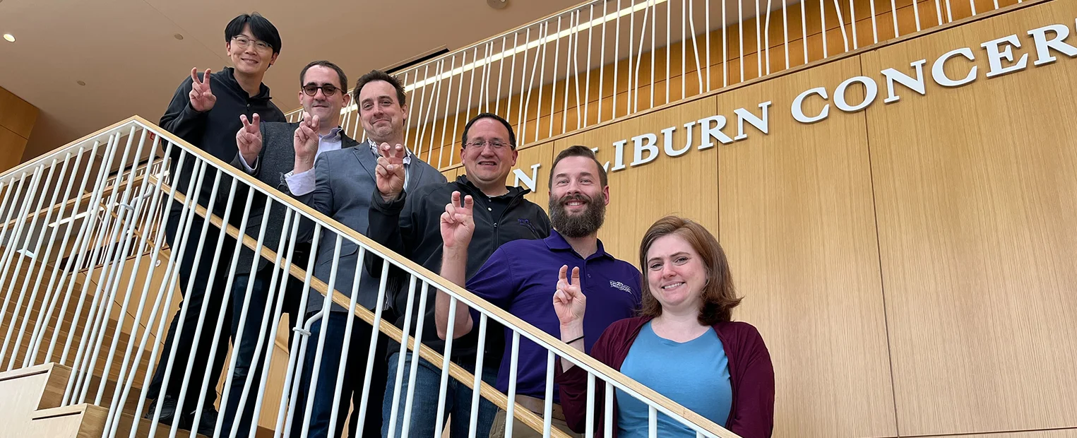A group from TCU Music stand on the stairs of the Van Cliburn Concert Hall at TCU