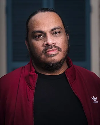 Joe Harjo wearing a black t-shirt and a red jacket