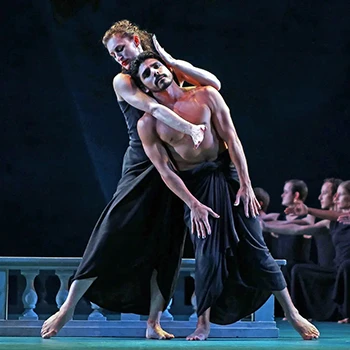 A female dancer cradles the head of a male dancer while both lean to the side