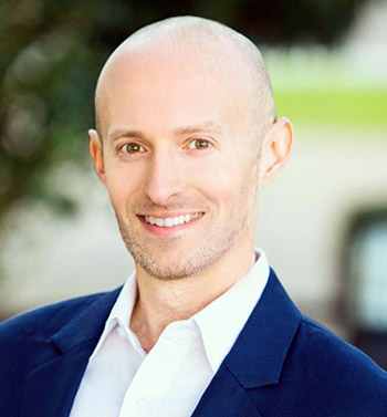 Corey Trahan, wearing a navy sport coat and white shirt