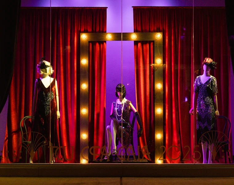 Three mannequins dressed in 1920s cabaret attire decorate a window display