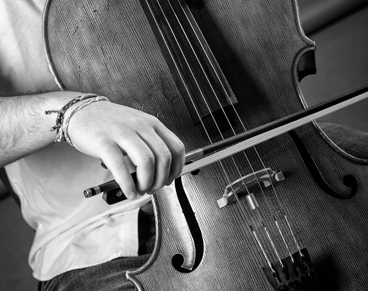 A cellist draws his bow across the strings