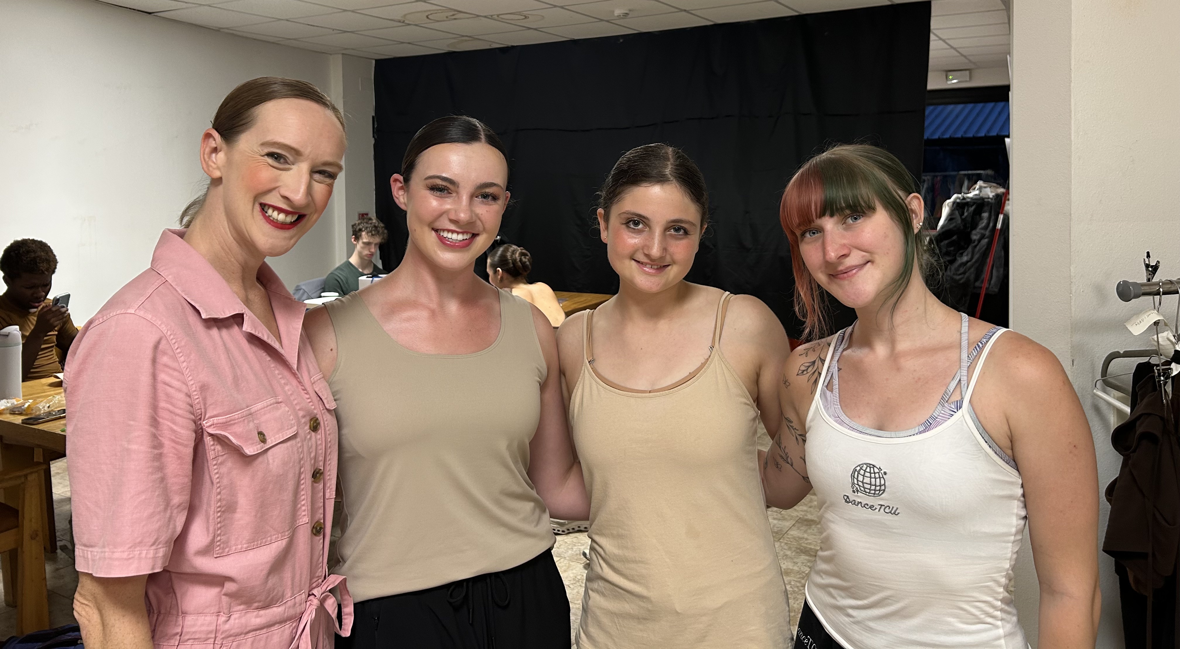Dance students and faculty smile together backstage during a study abroad experience in Italy.