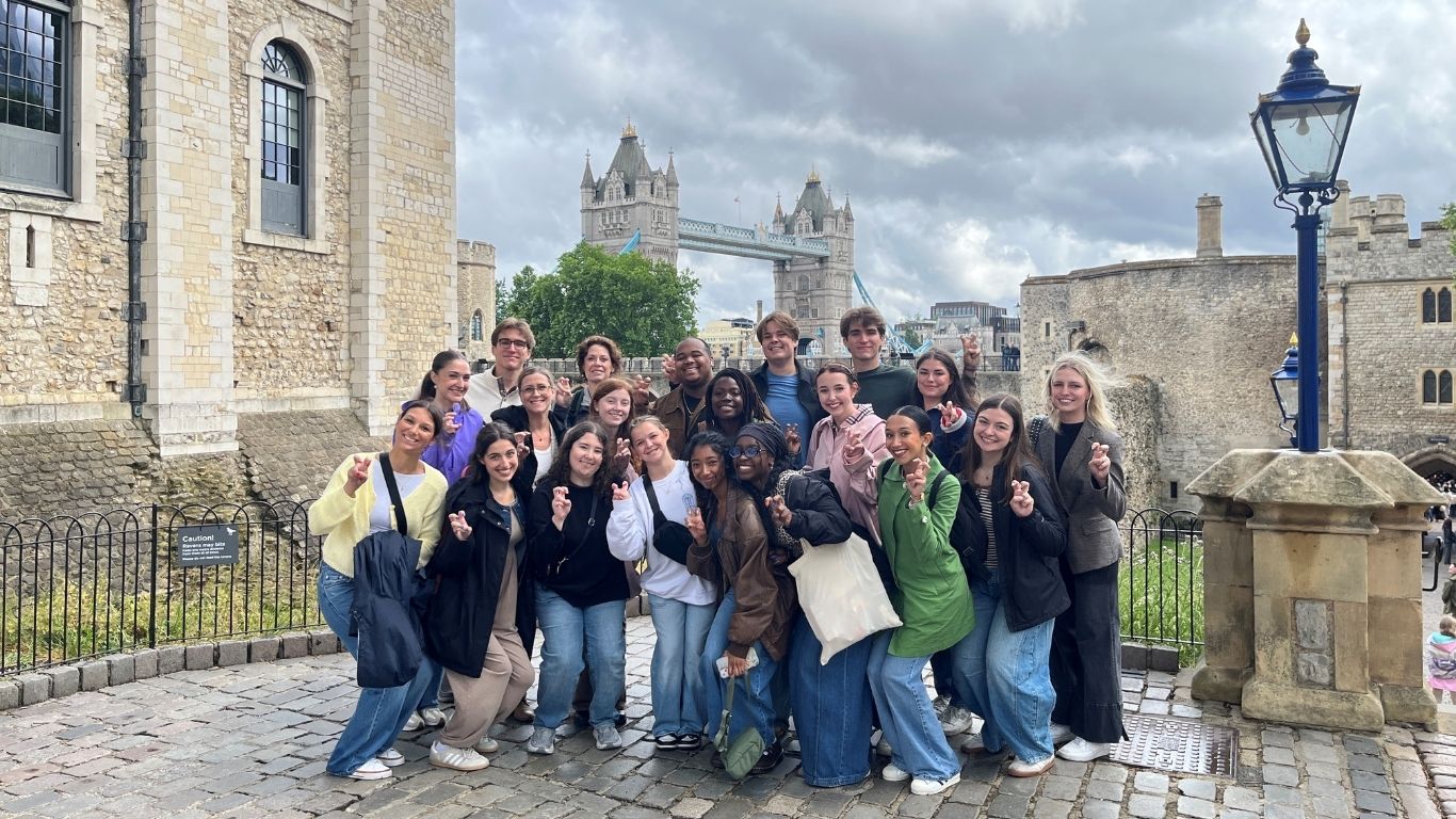 Theatre students pose together near Tower Bridge in London during a study abroad experience.