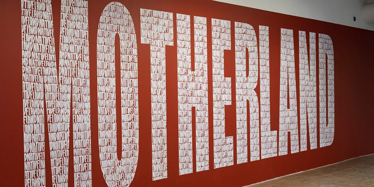 MOTHERLAND in white letters on a red wall