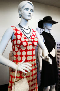 Two mannequins wearing dresses from the TCU garment collection, one red and one black.