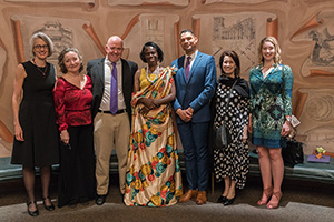 A group of TCU professors, staff, and alumni stand with honoree Godelieve Mukasarasi