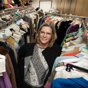 Stephanie Bailey stands among racks of historic costumes
