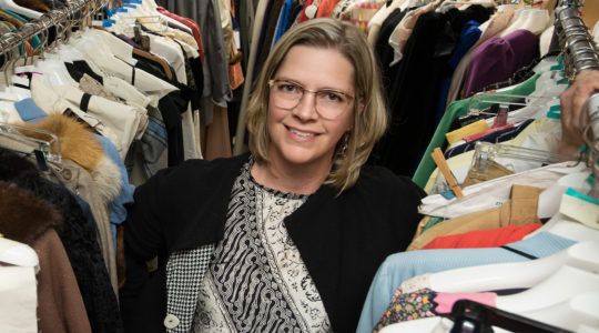 Stephanie Bailey stands among racks of historic costumes