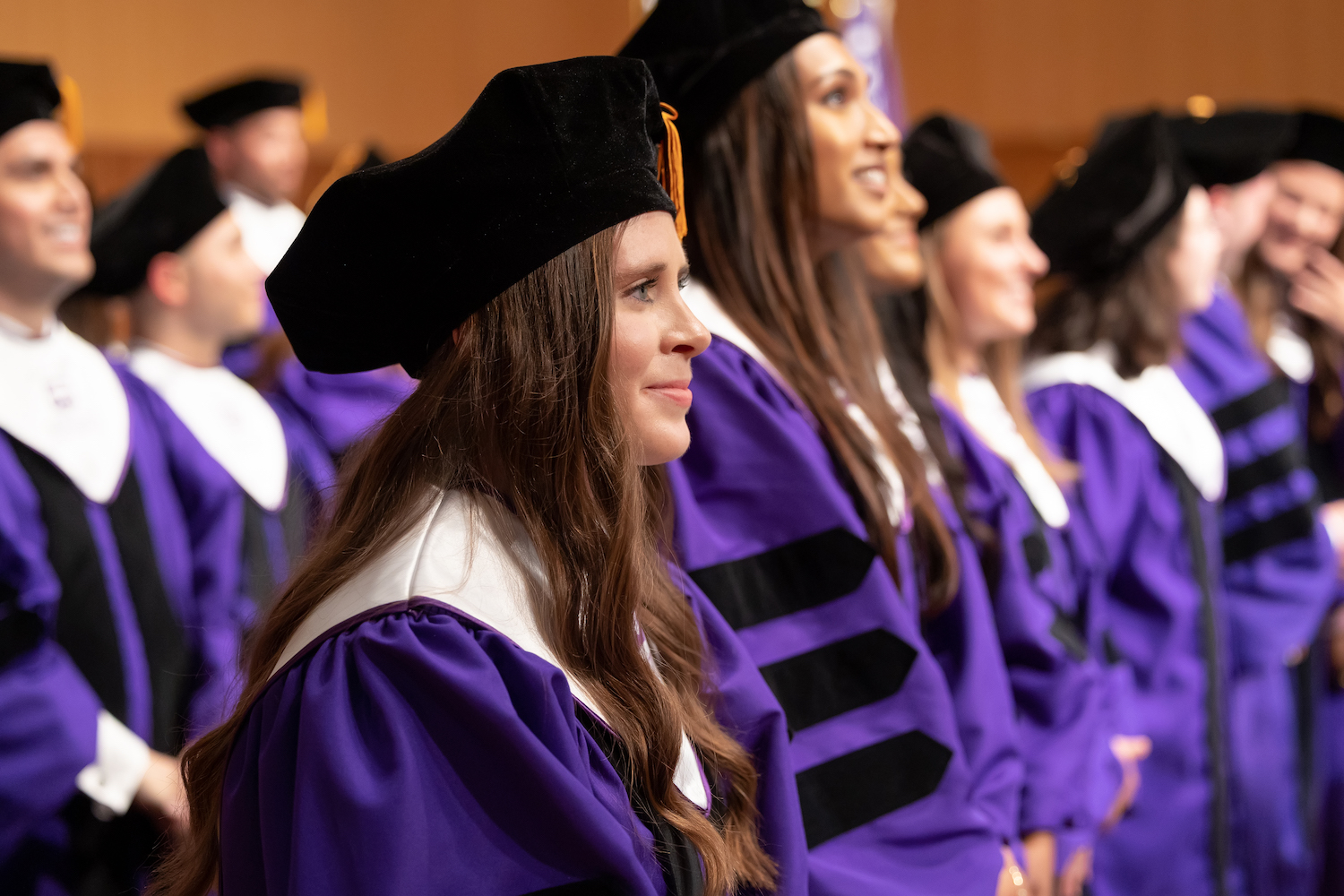 Graduating students wait to be called on stage at the hooding ceremony in the Van Cliburn Concert Hall. 