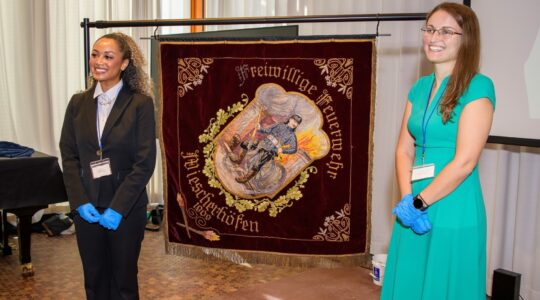 First-year Master of Arts in Art History student Abbey Sempebwa (left) stands in front of the Wiescherhöfen Banner.