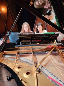 A Music Preparatory instructor teaches a young girl piano in the PepsiCo Recital Hall at TCU.