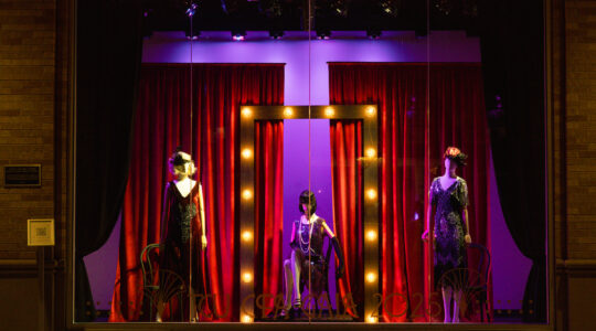 A 1920s-inspired window display featuring three mannequins dressed in flapper-style evening wear. The scene is framed by rich red velvet curtains, with a central illuminated rectangle outlined by vintage-style bulbs. The text "TCU CFA GALA 2025" appears at the bottom of the window.